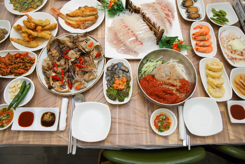 흰살 회와 간장게장, 회무침, 찐 새우, 전복, 튀김, 생선구이가 함께 차려진 시장형 횟집 한 상 전경