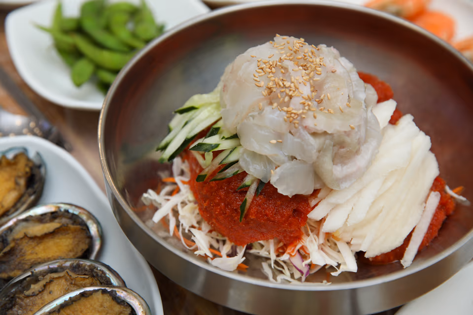 양푼에 수북하게 담긴 회덮밥과 전복구이, 에다마메가 곁들여진 1인 세팅