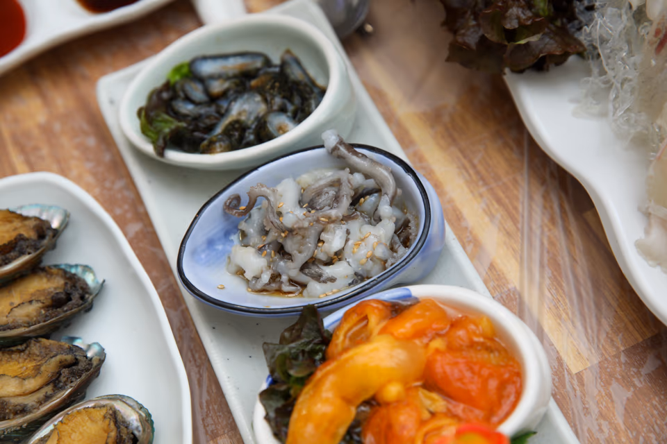 전복구이, 산낙지, 꼴뚜기무침, 멍게젓 등 해산물 반찬이 모인 횟집 한 상