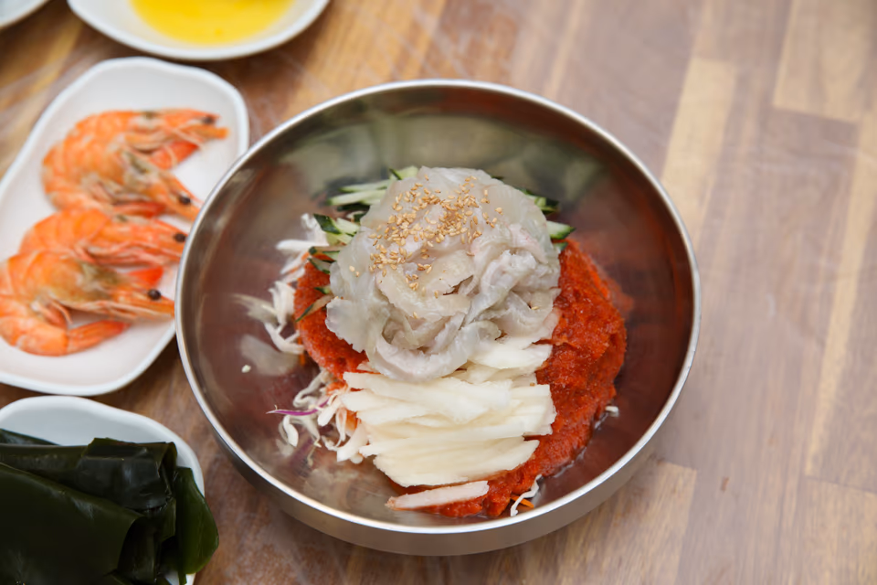 양푼에 담긴 회덮밥과 새우·호박 반찬이 함께 차려진 아침 상차림
