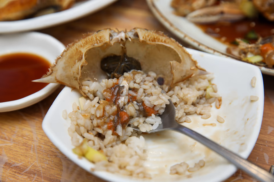 Shell bibimbap finished inside the top shell with rice and roe stirred together, real photo of the final mixed bowl
