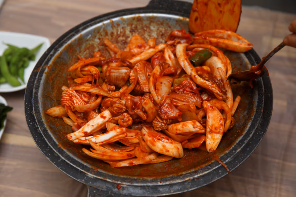 연탄에 초벌한 산꼼장어에 빨간 양념을 올려 양파·대파와 함께 볶은 양념 꼼장어 한 판