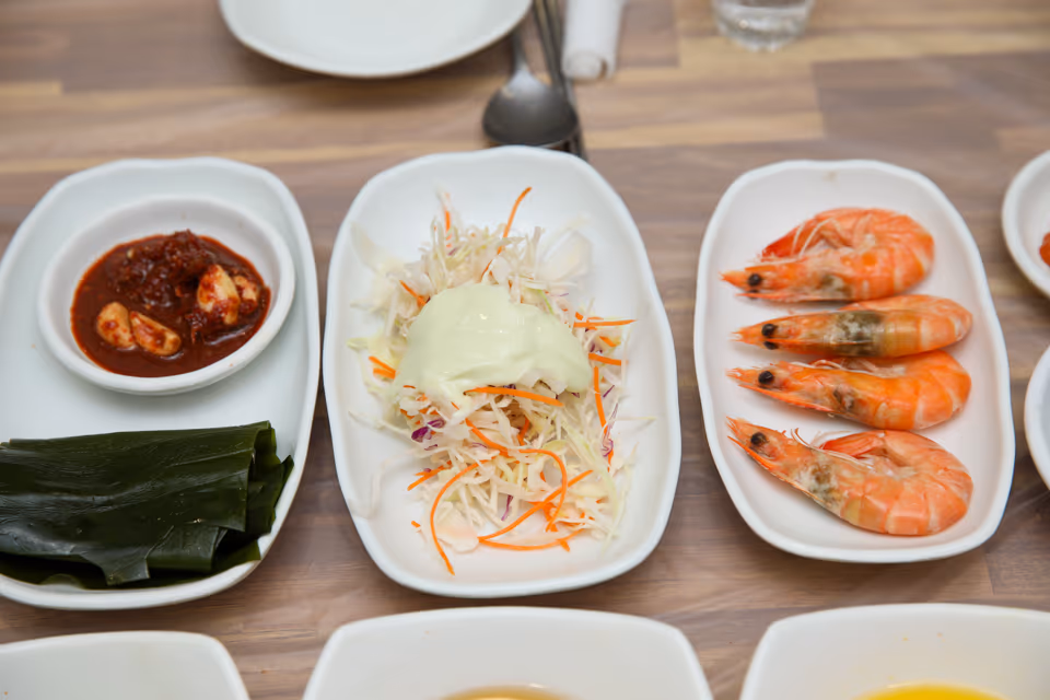 접시에 담긴 찐 새우, 껍질째 붉게 익어 예약 때 미리 빼 달라고 말할 수 있는 곁들임